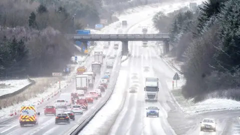 PA Media Motorists drive through the sleet and snow along the M8 motorway near Bathgate in West Lothian as Storm Eunice sweeps across the UK