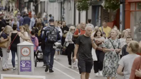 BBC People walking through a street in St Helier, Jersey