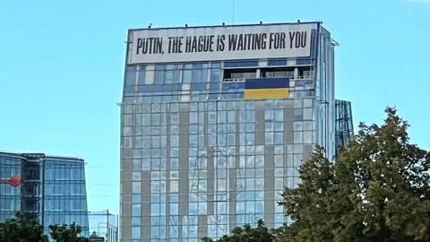 A banner on a building in central Vilnius, Lithuania, reads: "Putin, the Hague is waiting for you"