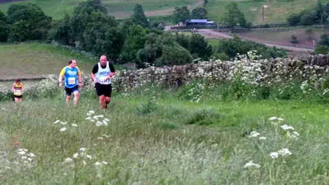 Alamy Runners tackling a hill