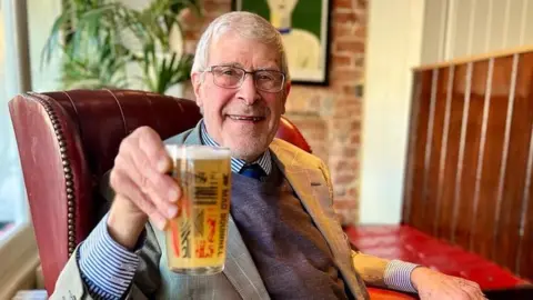 Roger Protz holding a pint of beer