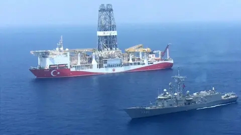 Getty Images The drilling ship Yavuz escorted by a Turkish warship (pic from Turkish defence ministry)