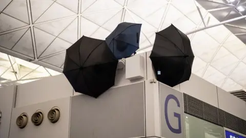 EPA Umbrellas block CCTV cameras as anti-government protesters attend a demonstration