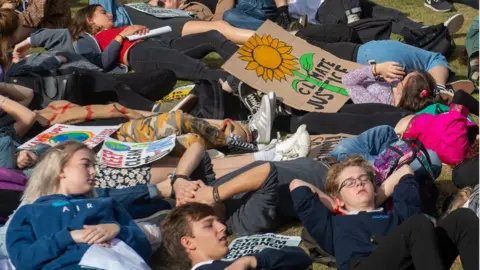 PA Media Children hold a similar "die in" in Cambridge