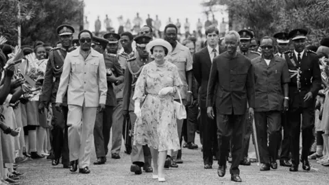 Getty Images Queen Elizabeth II is met by President Julius Nyerere at Dar es Salaam airport, at the start of a three-day State Visit, 18th July 1979.