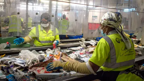 Phil Coomes / BBC Two women sorting through recycling