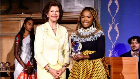 AFP Queen Silvia of Sweden posing with Yanga Sobetwa.