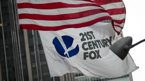 Getty Images A 21st Century Fox flag flies outside the News Corporation building in Midtown Manhattan, December 14, 2017 in New York City.