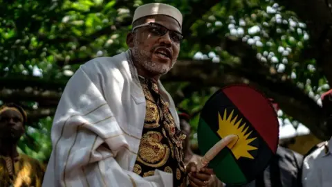 Getty Images Political activist and leader of the Indigenous People of Biafra (IPOB) movement, Nnamdi Kanu, wears a Jewish prayer shawl as he walks in his garden at his house in Umuahia, southeast Nigeria, on May 26, 2017