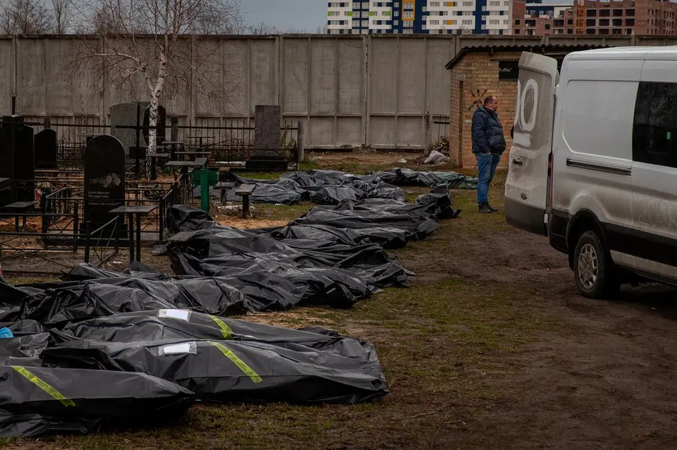 BBC The line of body bags at the Bucha cemetery, waiting to be processed and buried.