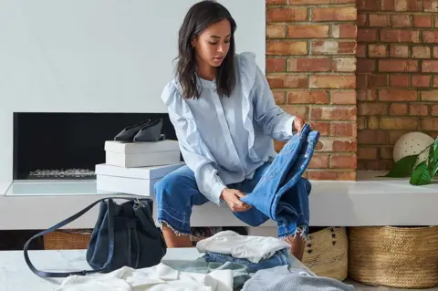 Amazon Young woman looking at clothes she's ordered