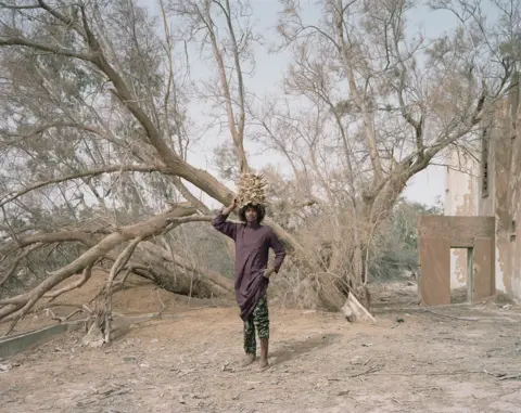 Edgar Martins Portrait of a man standing by a tree