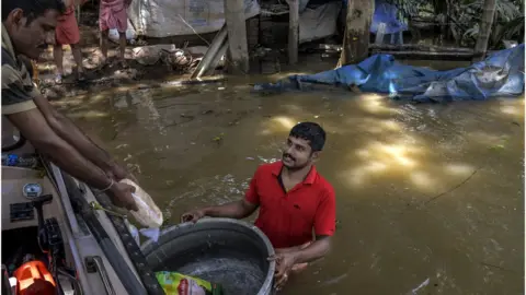 Getty Images Border Security Force (BSF) distribute food food and water to the residents who are stuck in their houses