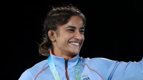 Getty Images Vinesh Phogat receiving a gold medal at the Commonwealth games 2022