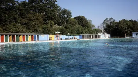View Pictures/Getty Images A person swims in the lido on a summer's day