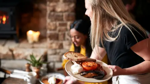 Getty Images Stock image of a waitress serving food