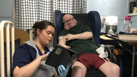 BBC Nurse, Paige Calved shows Jon how the wound care app works