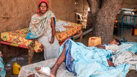 AFP A mother looking after her daughter who was wounded in shelling on Humera, Ethiopia - 22 November 2020