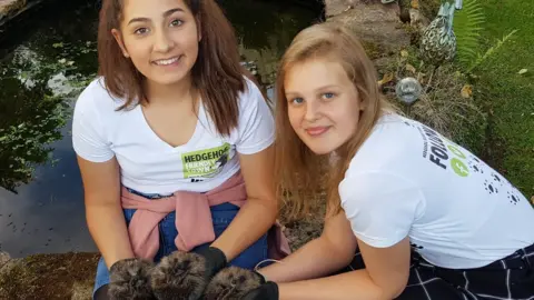 Family photo Kyra Barboutis and Sophie Smith with hedgehogs