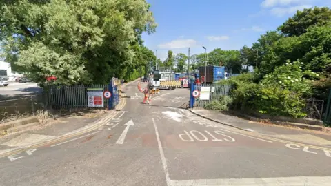 Google Google street view image of the recycling centre with big green gates and signs