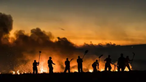 PA Fire fighters tackle a wild fire on Winter Hill near Bolton. Winter Hill is part of the West Pennine Moors. 28 June 2018.