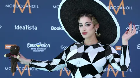 EPA France's La Zarra holding a Mr Bean teddy on the Eurovision turquoise carpet in Liverpool