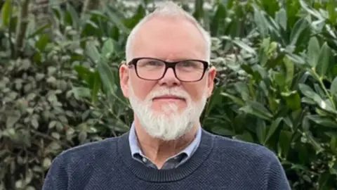 Liberal Democrats Alan Hagger standing in front of a bush