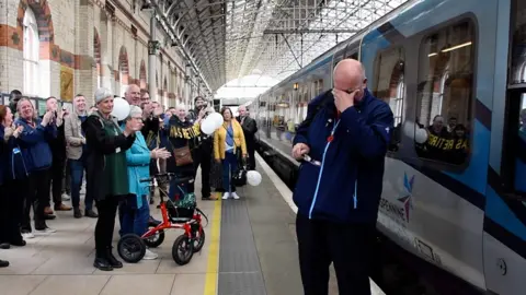 Joe Crean being applauded by friends and family at Manchester Piccadilly