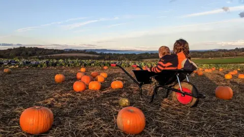 Eve-Marie Josse Eve-Marie Josse's kids in a pumpkin patch wheelbarrow