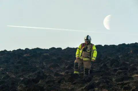 Getty Images Firefighters at moorland fire near Marsden