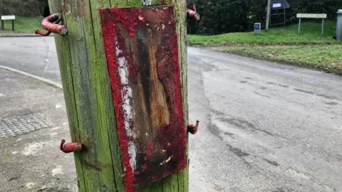 Shaun Whitmore/BBC A letterbox removed from a post in Wixoe