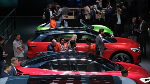 Getty Images Visitors look at Volkswagen electric cars during the press days at the 2019 IAA Frankfurt Auto Show