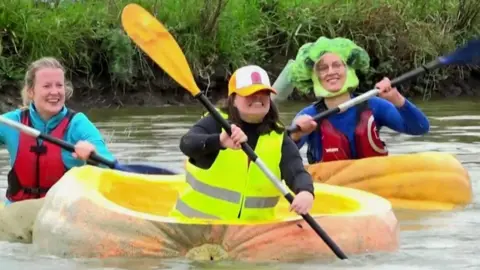 Kayakers in giant pumpkin boats