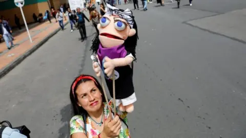 Reuters A woman holds a puppet during a protest as a national strike continues in Bogota, Colombia, November 27, 2019