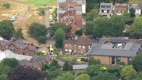 Aerial image showing ambulances parked outside the school, along with an air ambulance parked on a field opposite