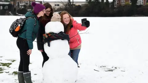EPA Woman take a selfie with a snowman in High Wycombe, Buckinghamshire.