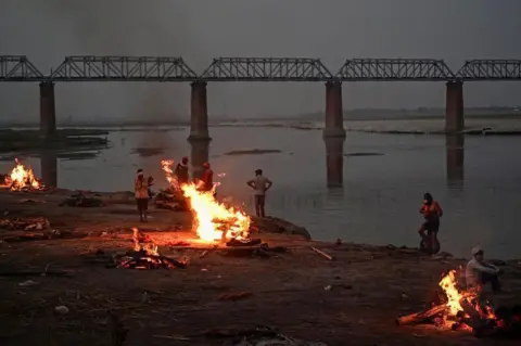 Getty Images Funeral pyres are lit by the Ganges in Allahabad, where bodies have been washing downstream for days