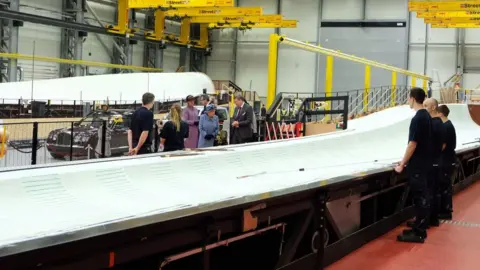 The Royal Family The Queen talking to factory workers