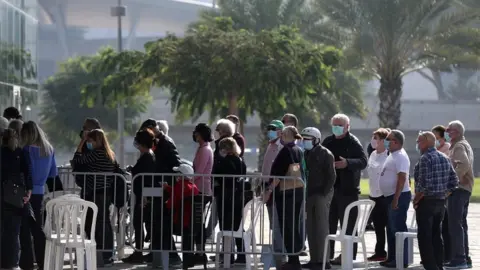 EPA People waiting in line to get the first dose of coronavirus vaccine, in the Heichal Shlomo Sports Arena that turned into a massive vaccination center in Tel Aviv, Israel, 22 December 2020