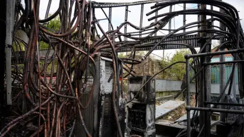 Getty Images The burned out cabling system of a destroyed communications junction