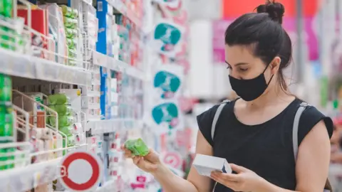 Getty Images Woman wearing a mask in a supermarket