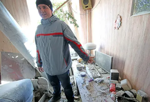 Getty Images A man shows a bomb-damaged room from shelling by Russian troops in a residential area in Piatykhatky, Kharkiv, north-eastern Ukraine