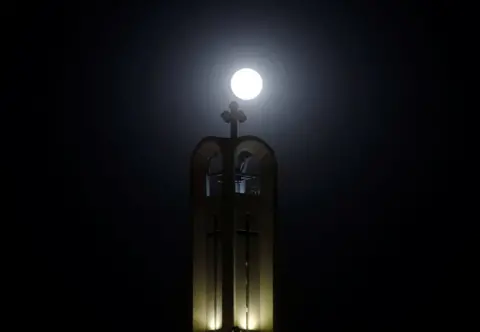 Amr Abdallah Dalsh / Reuters The moon rises behind The cross of St Antony Church