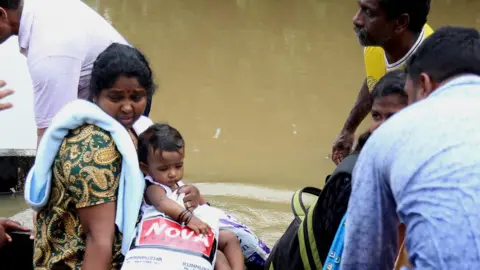 EPA People take a boat to safety in Kochi