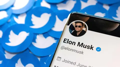 Reuters Elon Musk's Twitter profile is seen on a smartphone placed on printed Twitter logos in this picture illustration taken April 28, 2022.