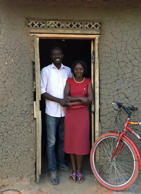 BBC News Herbat and Lucy standing in front of their house at Bidi Bidi