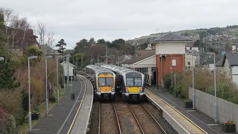 Milepost98 Two trains pass each other at Whitehead station