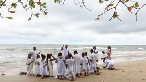AFP Group of people praying on beach, 9 September