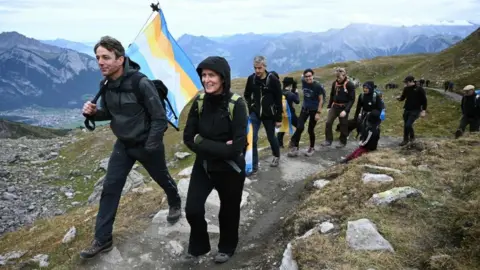 Getty Images People take part in a funeral march for a glacier lost to global warming