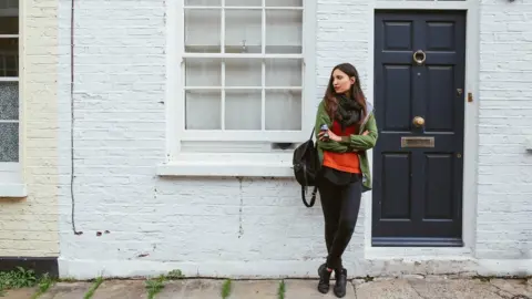 Getty Images woman outside house